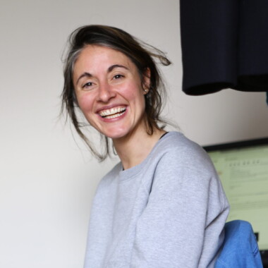 Helen Felcey smiles at the camera wearing a grey sweatshirt.
