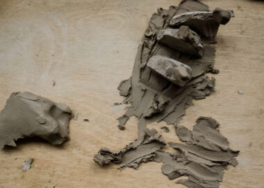 Pieces of dried clay are pressed into wet clay to make a sculpture.