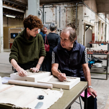 Sarah Fraser helps a festival visitor press moulding ceramics.