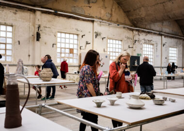 Visitors looking at ceramics displayed on large plinths in the middle of Spode China Hall in Stoke-on-Trent.