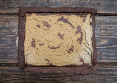 A slab of red clay with yellow slip cracking on top.
