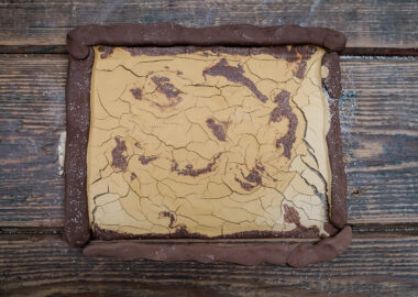 A slab of red clay with yellow slip cracking on top.