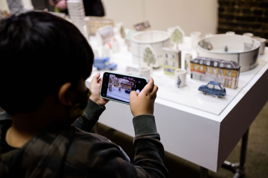 Young boy takes photo of Helen Beard's ceramic work at British Ceramics Biennial 2021