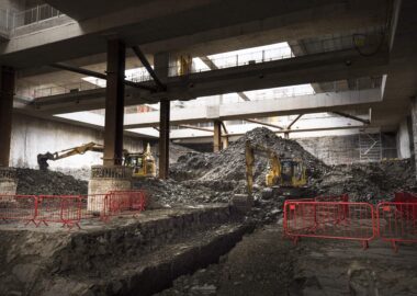 Excavators working in a large underground space.