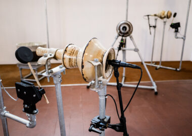 A ceramic pot with a microphone in the mouth and a mechanical beater at the other end as part of Sequenced Ceramics by Copper Sounds, exhibited at the 2023 British Ceramics Biennial.