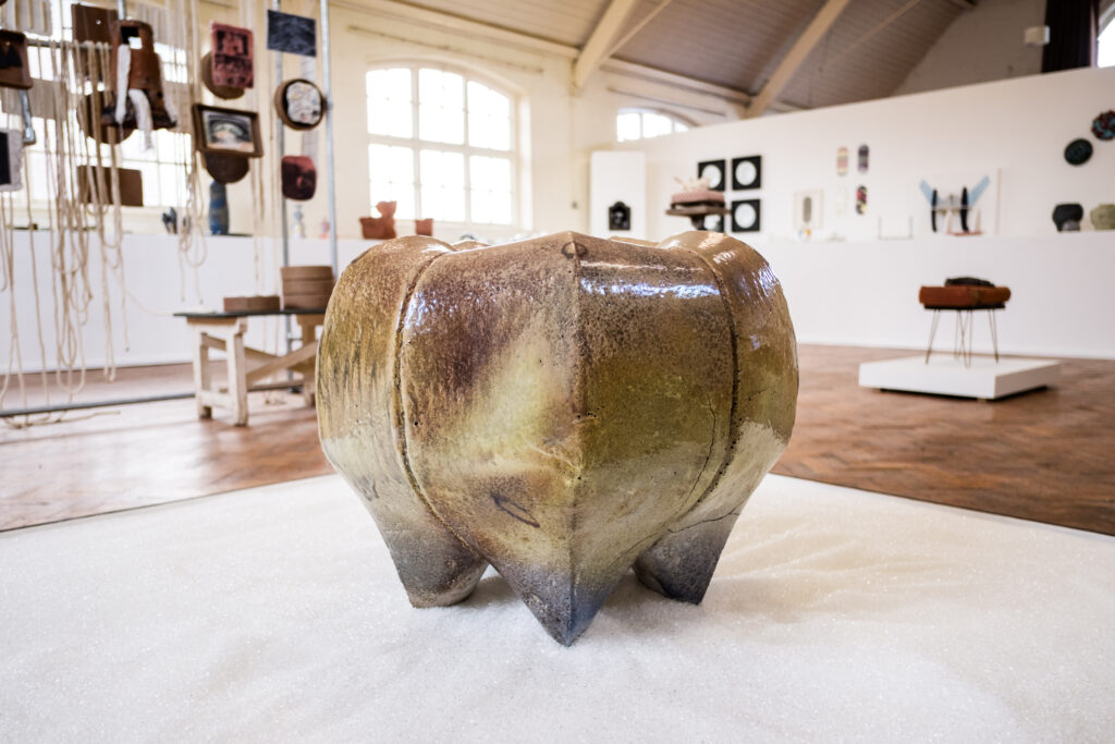 An apple-like clay stool as part of Leora Honeyman's work in the 2023 British Ceramics Biennial.
