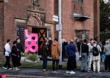 A line of people waiting to get into the opening night of the 2023 British Ceramics Biennial at All Saints Church in Stoke-on-Trent.