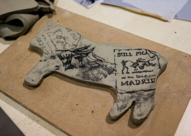 Rolled-out clay cut into the shape of a bull and printed with bull-themed stamps.