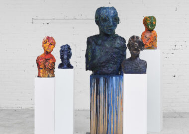 A series of ceramic busts on plinths painted with colourful oil paints.
