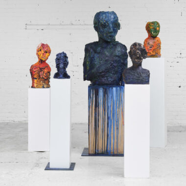A series of ceramic busts on plinths painted with colourful oil paints.